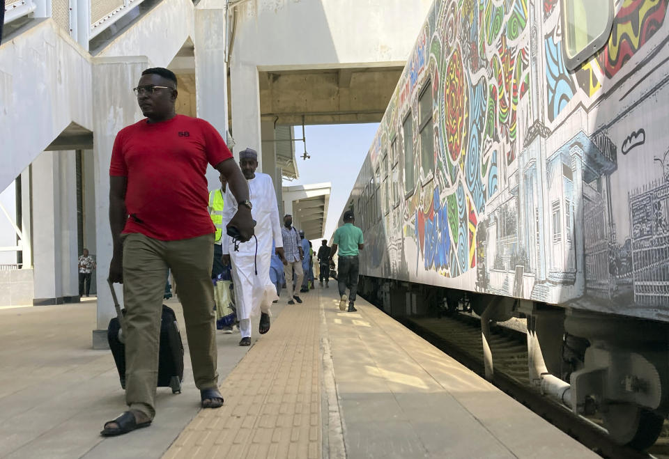 Passengers disembark from a train at the train station in Abuja, Nigeria, Monday, Dec. 5, 2022. Train service in Nigeria's capital city resumed on Monday, eight months after assailants attacked a train with explosives and gunfire, killing seven people and abducting dozens of passengers. (AP Photo/Chinedu Asadu)