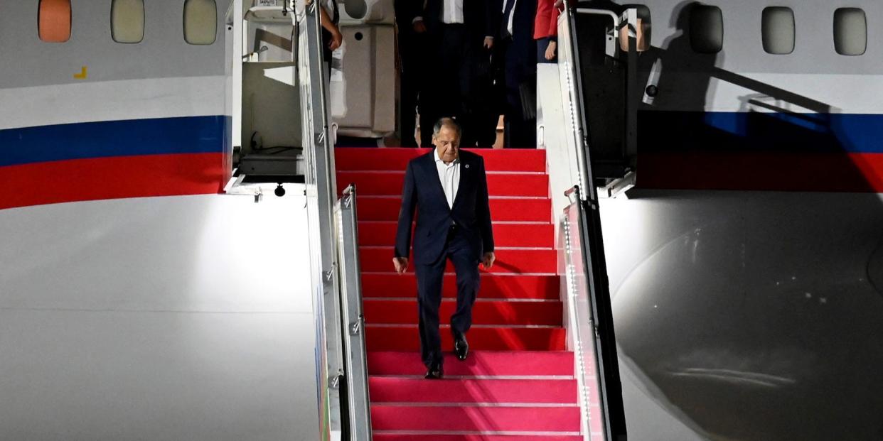 Russian Foreign Minister Sergey Lavrov, center, walks down the stairs of his plane upon arrival to attend the G20 Summit at Ngurah Rai International Airport in Bali, Indonesia, Sunday, Nov. 13, 2022.