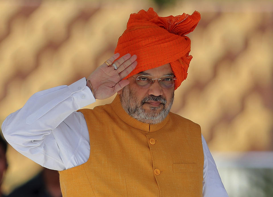 FILE - In this Saturday, Aug. 24, 2019, file photo, Indian Home Minister Amit Shah salutes during the graduation ceremony parade of Indian Police Service probationers at Sardar Vallabhbhai Patel National police academy in Hyderabad, India. Shah says normalcy has returned in most areas in Indian-controlled Kashmir but the detention of politicians and the blockade of the internet and social media are continuing because of security concerns. Asked by lawmakers in Parliament on Wednesday, Nov. 20, how soon the restrictions are likely to be lifted, Shah says authorities have to fix priorities when it comes to security and the fight against terrorism. India stripped the region of its semi-autonomous powers and implemented a strict clampdown on Aug. 5. (AP Photo/Mahesh Kumar A., File)