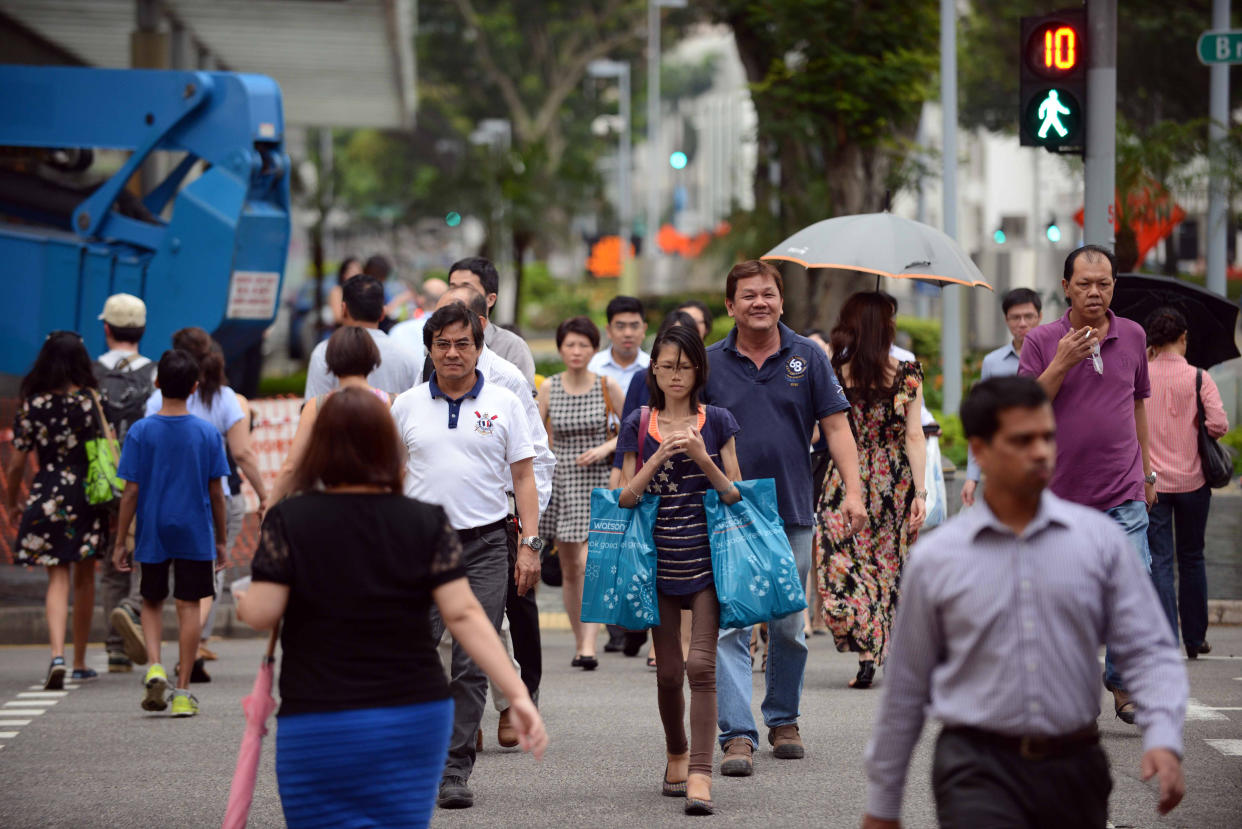 This photo taken on January 7, 2015 shows pedestrians crossing the road at Bras Basah in Singapore.   AFP PHOTO /MOHD FYROL / AFP / MOHD FYROL        (Photo credit should read MOHD FYROL/AFP via Getty Images)