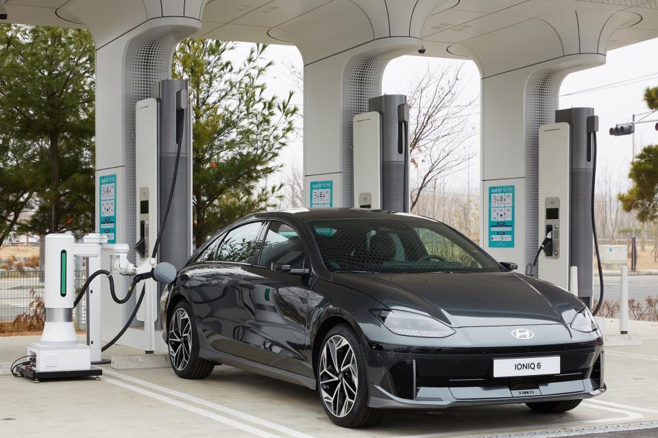 Hyundai's automatic charging robot plugging a charger into its electric Ioniq 6 sedan.