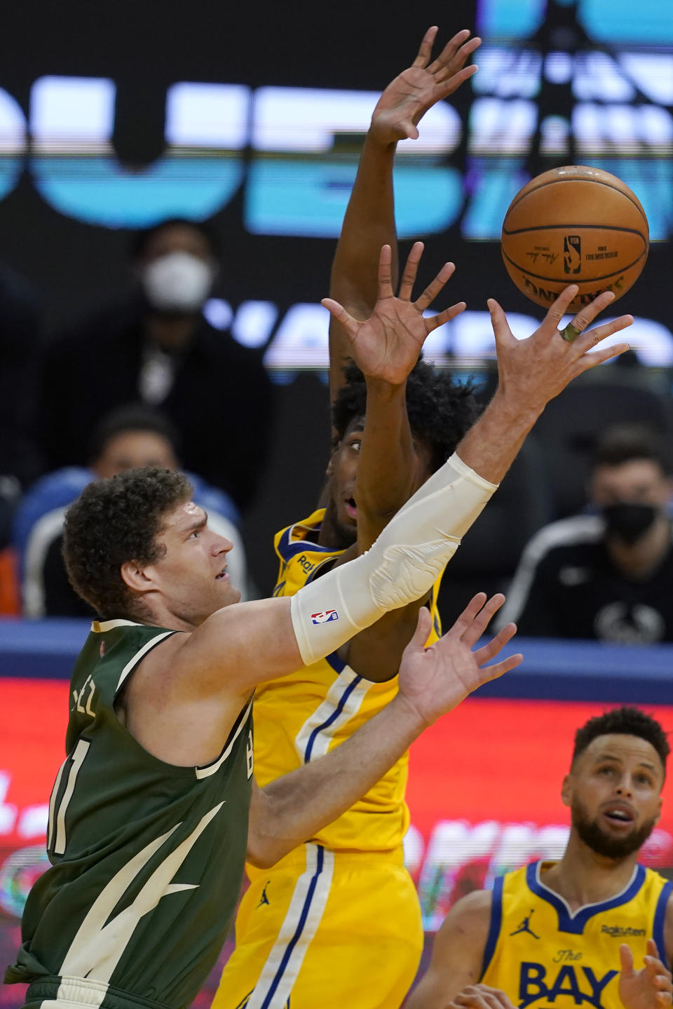 Milwaukee Bucks center Brook Lopez, left, shoots against Golden State Warriors center James Wiseman during the second half of an NBA basketball game in San Francisco, Tuesday, April 6, 2021. (AP Photo/Jeff Chiu)