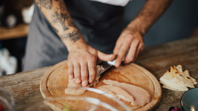 Chef cutting into chicken breast