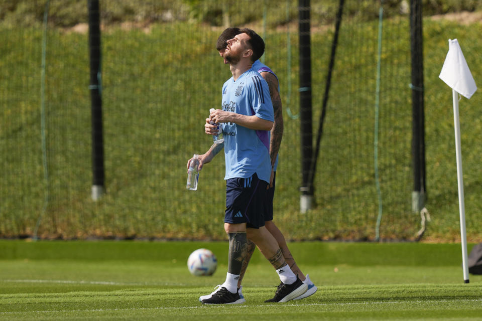 Lionel Messi enters to the pitch for a training session of Argentina's national soccer team in Doha, Qatar, Sunday, Nov. 27, 2022. (AP Photo/Jorge Saenz)