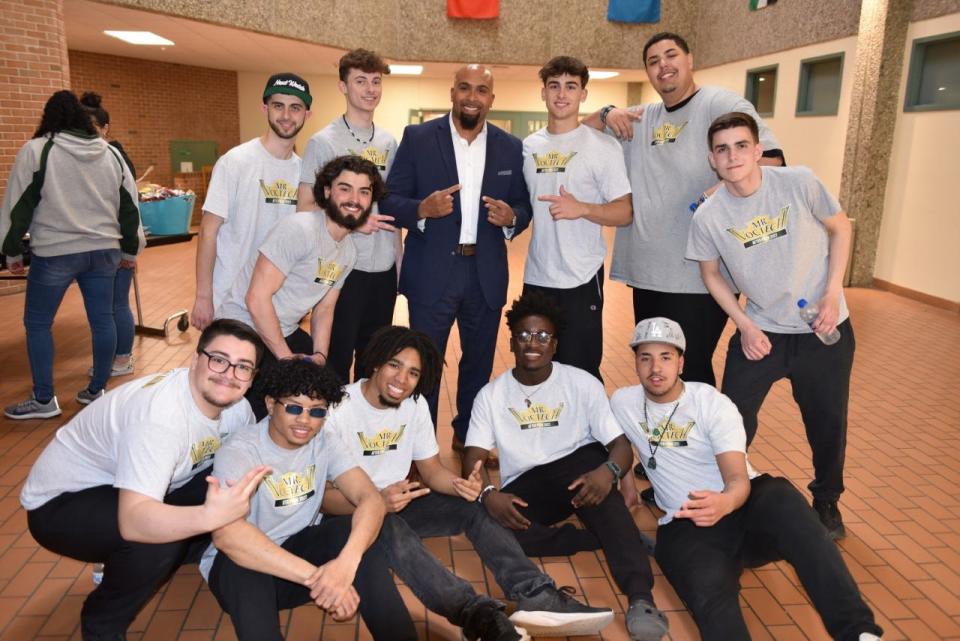 Greater New Bedford Regional Vocational Technical High School Principal Warley Williams (back row, center) poses for a group photo with the contestants of the 2022 Mr. Voc-Tech competition on April 8.