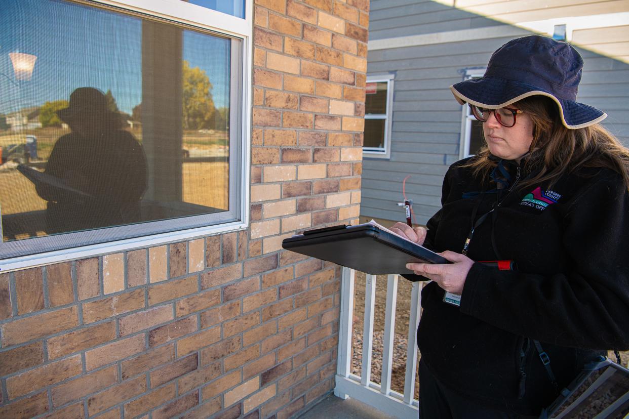 Stevie Townsend, data collector with the Larimer County Assessor's Office, takes notes as she collects exterior measurements of a new residential building under construction in the Hansen Farm subdivision on Monday in Fort Collins.