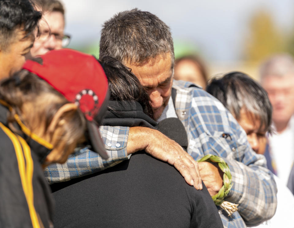 Darryl Burns, brother of victim Gloria Burns, embraces another family member of a victim during a Federation of Sovereign Indigenous Nations event where leaders provide statements about the mass stabbing incident that happened at James Smith Cree Nation and Weldon, Saskatchewan, Canada, at James Smith Cree Nation, Saskatchewan, Canada, on Thursday, Sept. 8, 2022. (Heywood Yu/The Canadian Press via AP)