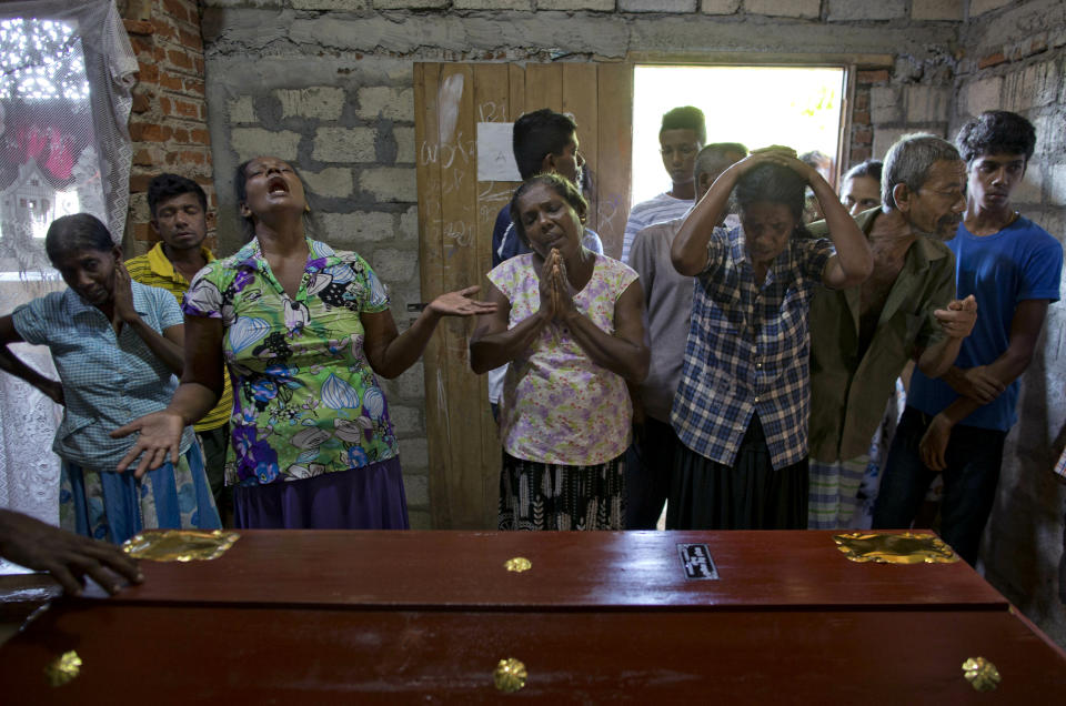 FILE - In this Monday, April 22, 2019 file photo, relatives weep by the coffin of 12-year Sneha Savindi, a victim of Easter Sunday's bombing at St. Sebastian Church, in Negombo, Sri Lanka. Roughly 250 people died in six coordinated suicide bombings that ripped through Sri Lanka on Easter Sunday. (AP Photo/Gemunu Amarasinghe, File)