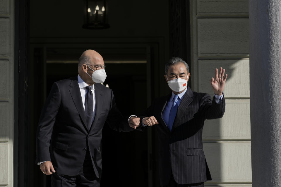 Greece's Foreign Minister Nikos Dendias left, welcomes his Chinese counterpart Wang Yi prior their meeting, in Athens, on Wednesday, Oct. 27, 2021. (AP Photo/Petros Giannakouris)