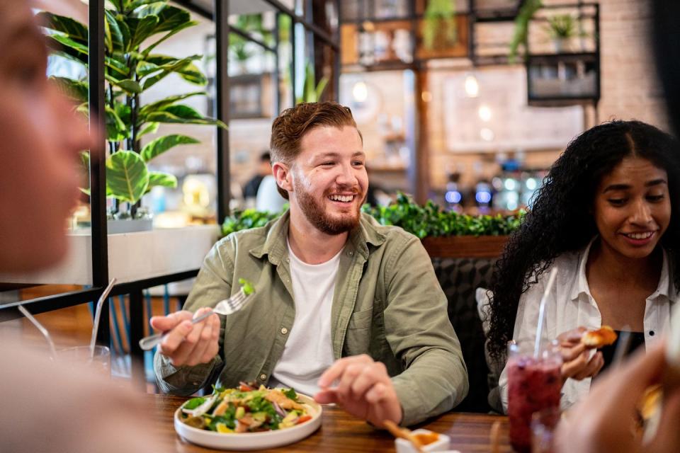 young man eating with his friends on a restaurant