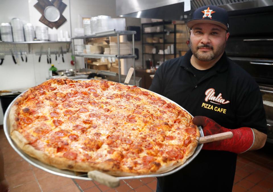 Owner Jose Morales holds the 28 inch Big Mama pizza Thursday, May 19, 2022, at Italia Pizza Cafe in Southaven.