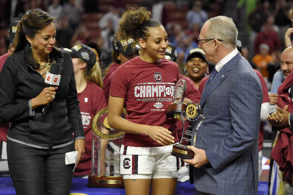 South Carolina's Mikiah Herbert-Harrigan, center, is presented with the MVP trophy by SEC Commissioner Greg Sankey, right, as ESPN's Carolyn Peck watches after defeating Mississippi State 76-62 in a championship match at the Southeastern Conference women's NCAA college basketball tournament in Greenville, S.C., Sunday, March 8, 2020. (AP Photo/Richard Shiro)