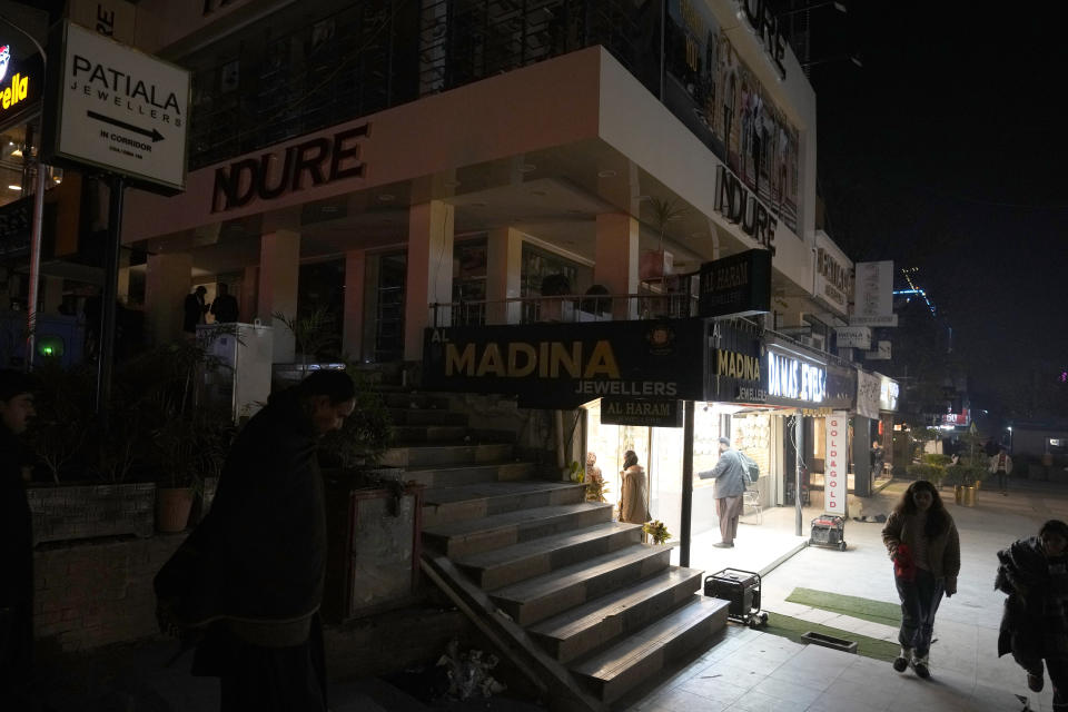 People visit a market, where some shopkeeper are using generators for electricity during a national-wide power breakdown, in Islamabad, Pakistan, Monday, Jan. 23, 2023. Much of Pakistan was left without power Monday as an energy-saving measure by the government backfired. The outage spread panic and raised questions about the cash-strapped government's handling of the country's economic crisis. (AP Photo/Anjum Naveed)