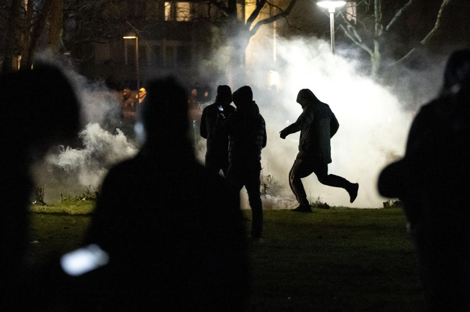 People are silhouetted by smoke after protests broke out at Rosengard in Malmo, Sweden, early Monday, April 17, 2022. The riots broke out following Danish far-right politician Rasmus Paludan’s meetings and planned Quran burnings in various Swedish cities and towns since Thursday. (Johan Nilsson/TT via AP)