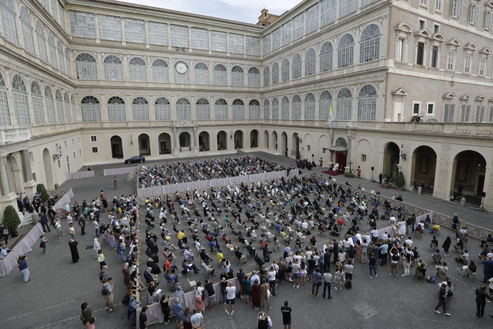 Faithful are sit distanced from each other as they listen to Pope Francis, white figure sitting at center right, during his general audience, the first with faithful since February when the coronavirus outbreak broke out, in the San Damaso courtyard, at the Vatican, Wednesday, Sept. 2, 2020. (AP Photo/Andrew Medichini)