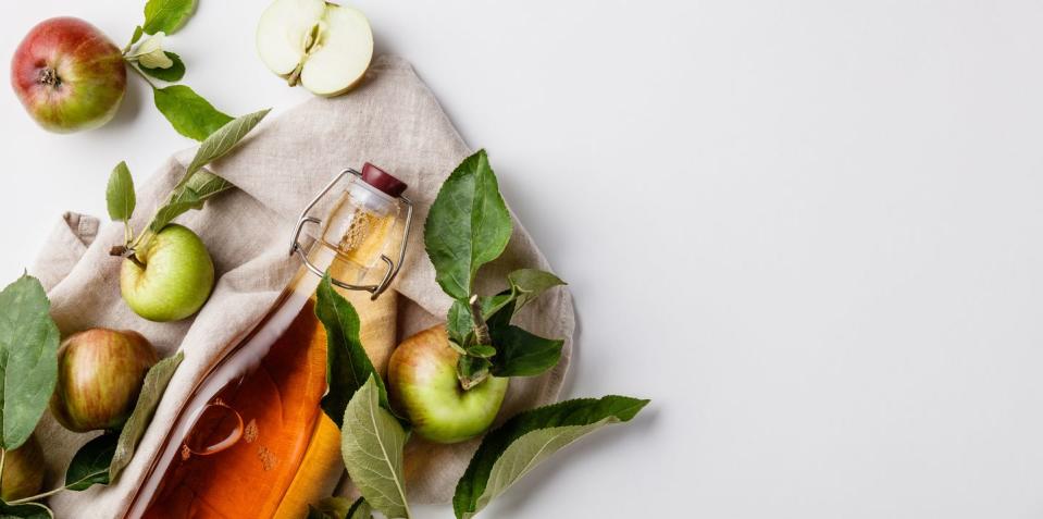 close up of apple cider vinegar in bottle against white background