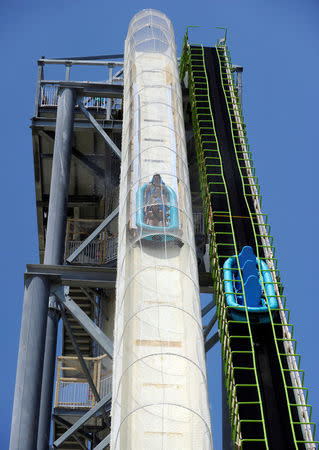 Riders take the plunge as an empty raft is lifted back to the top during the public opening of the Verruckt water slide at the Schlitterbahn Waterpark in Kansas City, Kansas July 10, 2014. REUTERS/Dave Kaup/File Photo