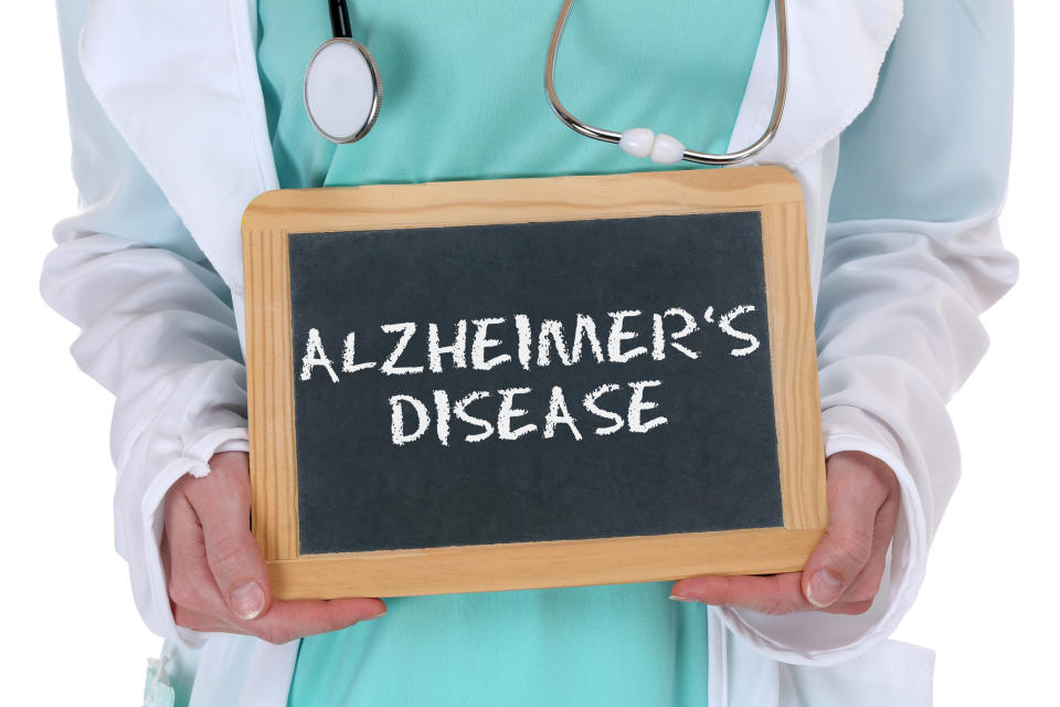 Doctor holding chalkboard tablet with Alzheimer's disease written on it