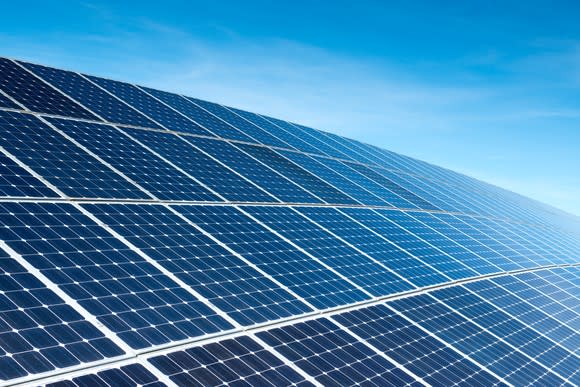 Large solar array with a sunny sky in the background.