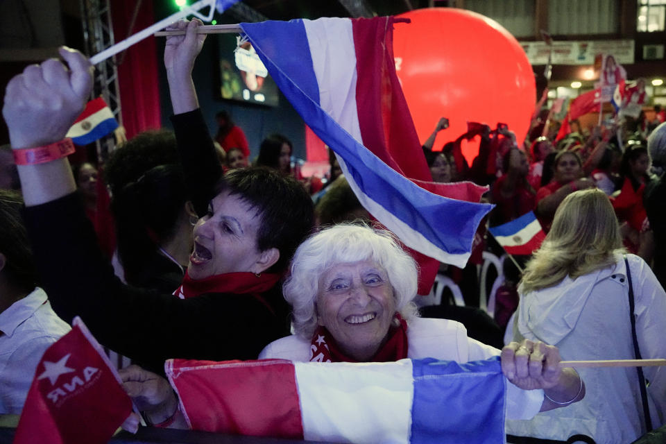 Followers of Santiago Peña, presidential candidate of the Colorado party, hold Paraguay's flags prior to a political rally in Asuncion, Monday, April 24, 2023. Paraguay's general elections are scheduled for April 30. (AP Photo/Jorge Saenz)