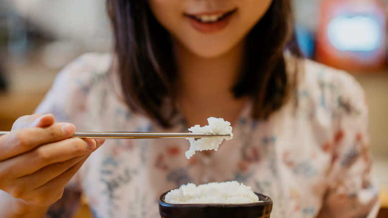 Woman eating rice with chopsticks