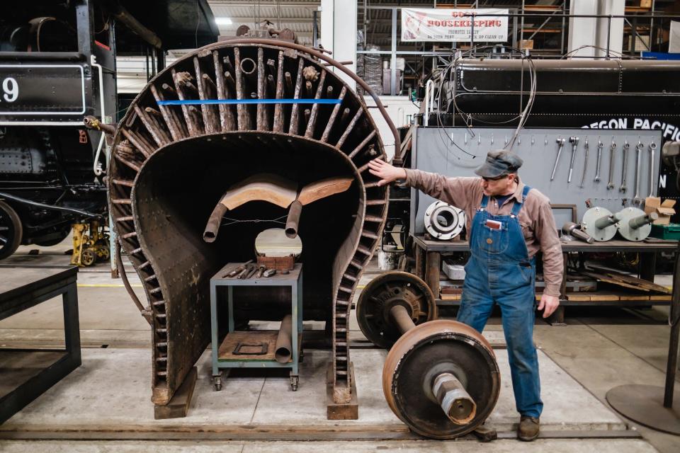 Tim Sposato, chief mechanical officer at The Age of Steam, talks about the functionality of steam engine boilers while standing next to the cutaway view on a scrapped boiler for guided tour purposes in April, at the Age of Steam Roundhouse Museum, in Sugarcreek.