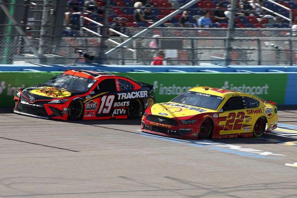 Martin Truex Jr (19) and Joey Logano (22) race through Turn 4 during a NASCAR Cup Series auto race at Phoenix Raceway, Sunday, March 14, 2021, in Avondale, Ariz. (AP Photo/Ralph Freso)