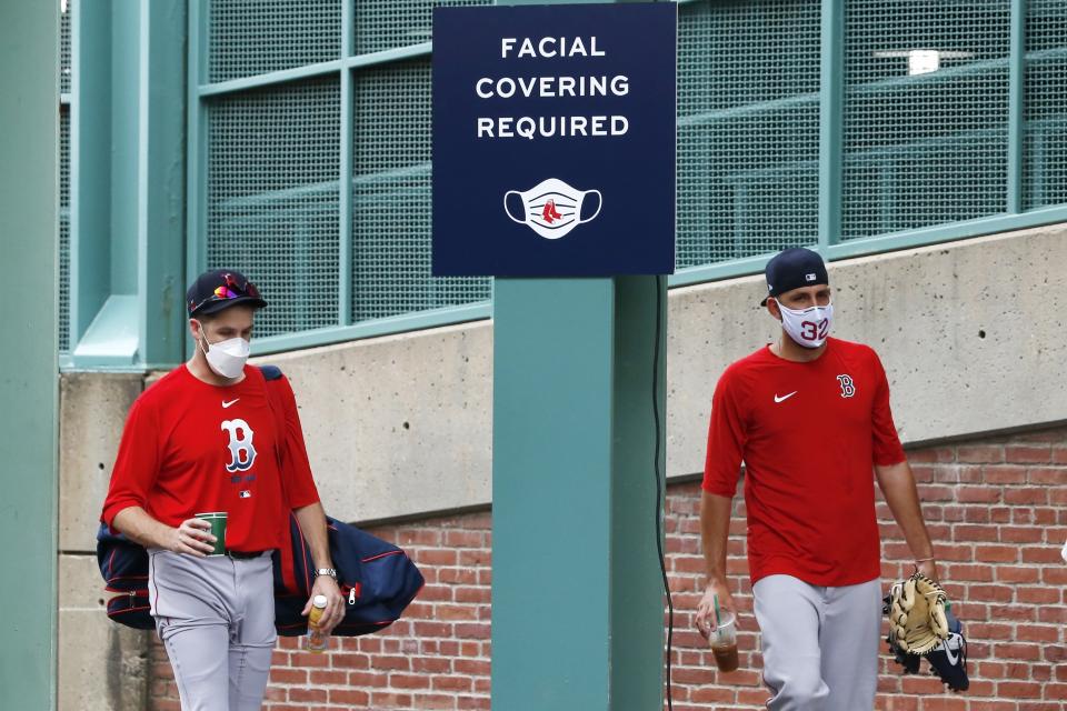 Boston Red Sox's Matt Barnes, right, walks to a bus with a teammate to be transported to an off-site facility for better social distancing between players out of concern for the coronavirus before baseball practice at Fenway Park, Sunday, July 5, 2020, in Boston. (AP Photo/Michael Dwyer)