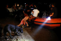 <p>A man holding a dog pushes an inflatable boat as locals are evacuated during a wildfire at the village of Mati, near Athens, Greece, July 23, 2018. (Photo: Alkis Konstantinidis/Reuters) </p>