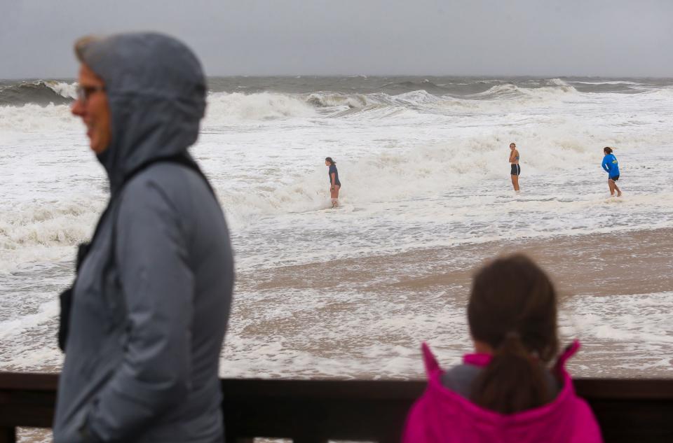 Adventurous visitors (from left) Rebecca Walsh, Tess Avery and Rebecca LeBlanc wade in the near-high tide at Cape Henlopen State Park as tropical storm Ophelia hits the Delaware coast Saturday afternoon, Sept. 23, 2023. The Lewes trio brought surf and boogie boards but declined to use them after seeing the churning surf conditions - and the park patrol shooed them onto the boardwalk soon after.