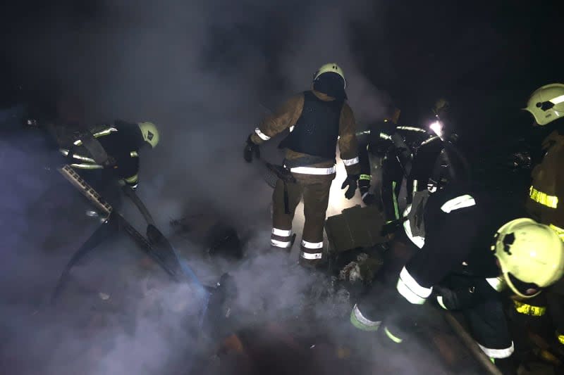 Rescuers inspect the scene following a Russian missile strike. -/Ukrinform/dpa