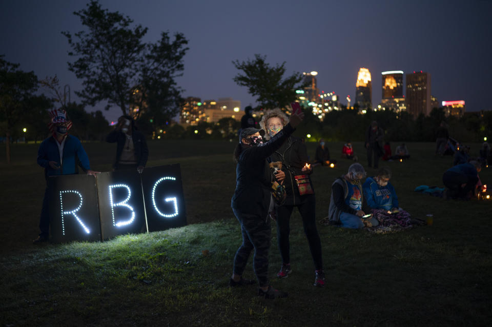 Two people take a selfie in front of Ruth Bader Ginsberg's initials during a memorial service for Ruth Bader Ginsburg, Sunday, Sept. 20, 2020 in Minneapolis. (Jeff Wheeler/Star Tribune via AP)