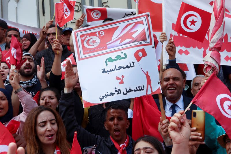 Supporters of Tunisian President Kais Saied carry flags and signs during a demonstration in Tunis