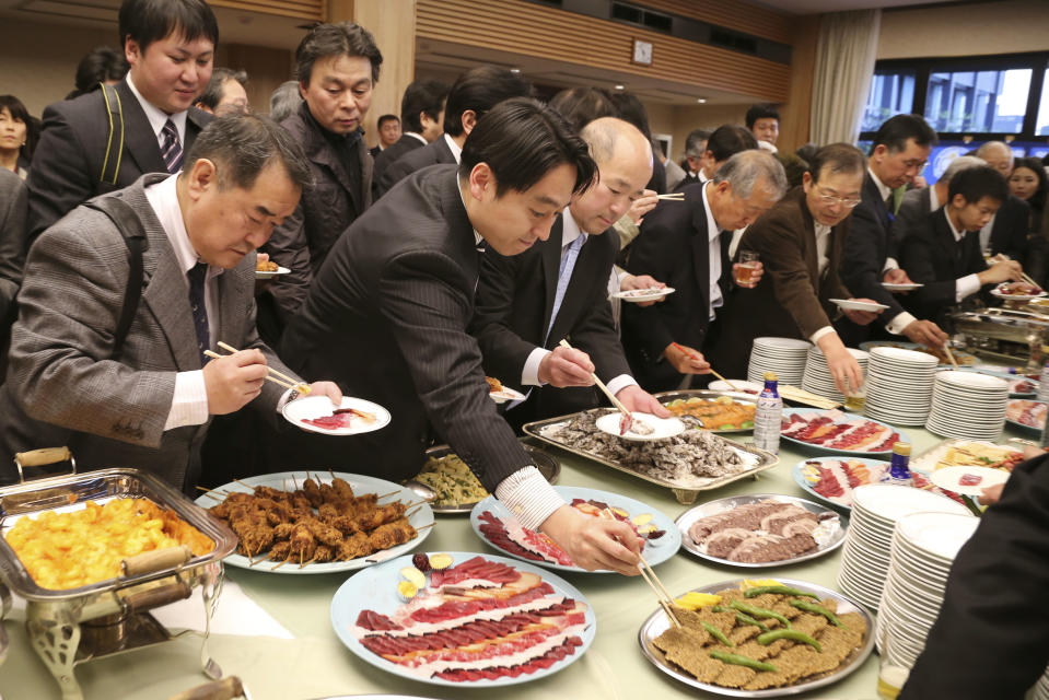 Supporters of Japan's whaling gather around the table for buffet during the 26th whale meat tasting event in Tokyo Tuesday, April 15, 2014. Hundreds of Japanese pro-whaling officials, lawmakers and lobby groups vowed to protect whale hunts despite the world court ruling that ordered the country’s Antarctic research culls must be stopped. (AP Photo/Koji Sasahara)