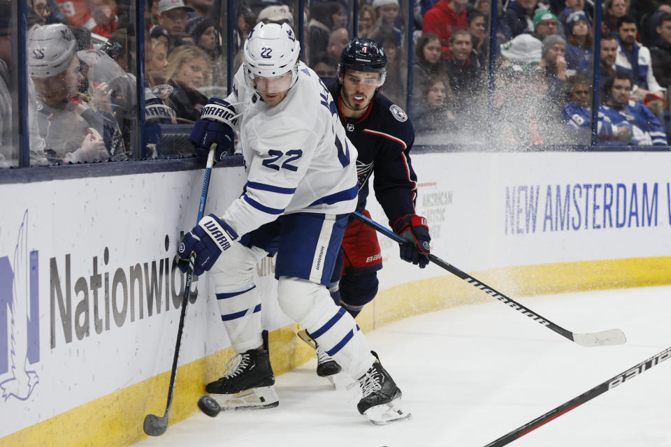 Toronto Maple Leafs' Jake McCabe, left, tries to clear the puck as Columbus Blue Jackets' Cole Sillinger defends during the second period of an NHL hockey game Friday, Dec. 29, 2023, in Columbus, Ohio. (AP Photo/Jay LaPrete)