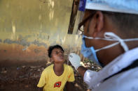 A health worker takes the nasal swab sample of a boy to test for COVID-19 in Gauhati, India, Friday, May 14, 2021. (AP Photo/Anupam Nath)