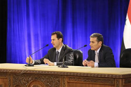 Syria's President Bashar al-Assad (L) meets with professors and students of political science college in Damascus April 13, 2014, in this handout photograph released by Syria's national news agency SANA. REUTERS/SANA/Handout via Reuters