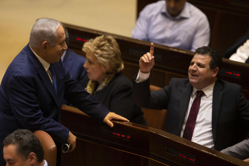 FILE - In this Dec. 26, 2018 file photo, Israeli Prime Minister Benjamin Netanyahu speaks with Israeli Knesset member Ayman Odeh during a session in Jerusalem, Israel. Israel's four Arab political parties are announcing a merger ahead of September elections, a move that aims to boost voter turnout among the country's Arab minority. The Palestinian nationalist Balad party announced late Sunday, July 28, 2019, that it would join a reunited Joint List of Arab parties, months after infighting fragmented the political alliance. (AP Photo/Sebastian Scheiner, File)