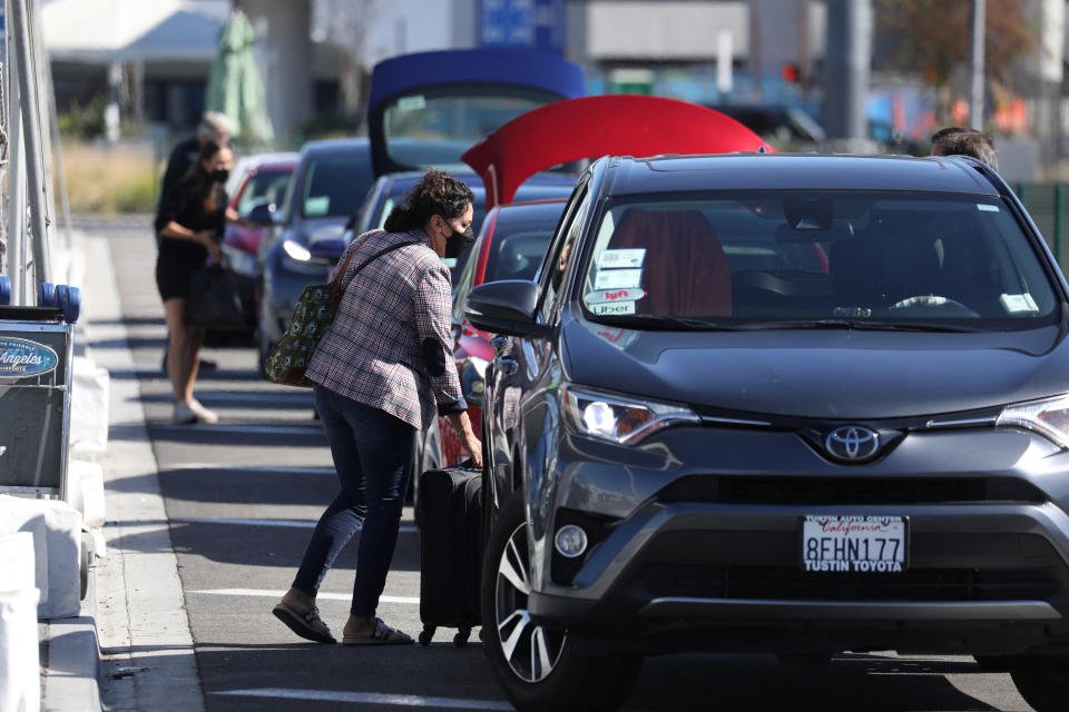 Passengers wait for Uber ride-share cars after arriving at Los Angeles International Airport (LAX) in Los Angeles, California, U.S. July 10, 2022.  REUTERS/David Swanson