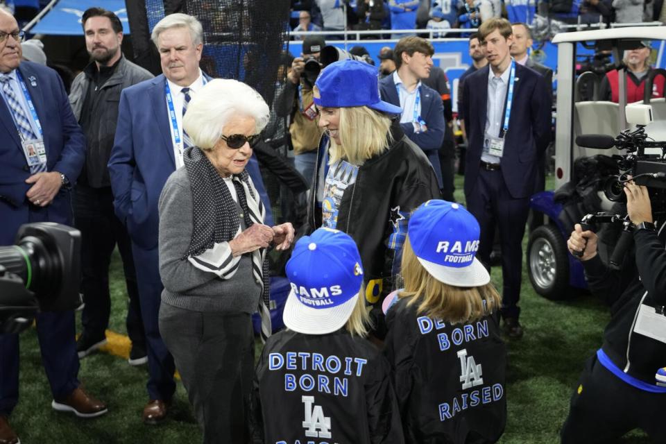 Kelly Stafford and two kids, wearing "Detroit Born, LA Raised" shirts, talk to Martha Firestone Ford