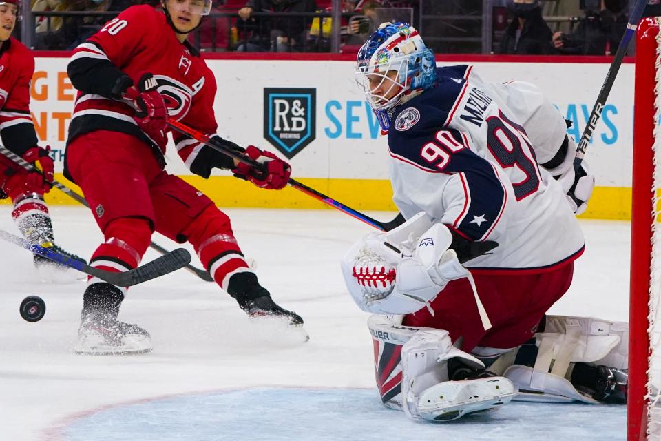 Jan 13, 2022; Raleigh, North Carolina, USA; Columbus Blue Jackets goaltender Elvis Merzlikins (90) watches the shot against the Carolina Hurricanes during the first period at PNC Arena. Mandatory Credit: James Guillory-USA TODAY Sports