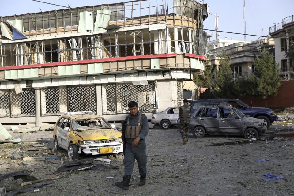 An Afghan security person walks around debris following an attack in Kabul, Afghanistan, Wednesday, Aug. 4, 2021. A powerful explosion rocked an upscale neighborhood of Afghanistan's capital Tuesday in an attack that apparently targeted the country's acting defense minister. (AP Photo/Rahmat Gul)