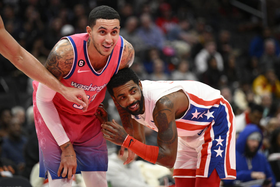 Washington Wizards forward Kyle Kuzma (33) and Brooklyn Nets guard Kyrie Irving, right, react during a foul shot in the first half of an NBA basketball game, Monday, Dec. 12, 2022, in Washington. (AP Photo/Nick Wass)