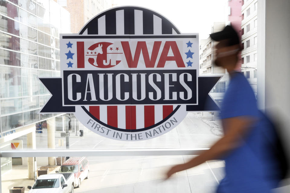 FILE - A pedestrian walks past a sign for the Iowa Caucuses on a downtown skywalk, in Des Moines, Iowa, on Feb. 4, 2020. Iowa Republicans have scheduled the party’s presidential nominating caucuses for Jan. 15, 2024, putting the first votes of the next election a little more than six months away. (AP Photo/Charlie Neibergall, File)
