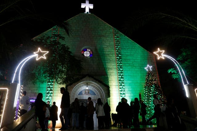 Palestinian Christians wait to pray at the midnight Christmas Eve mass (Adel Hana/AP)