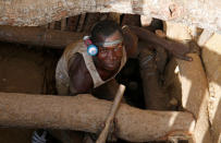 An artisanal gold miner emerges from a pit at an unlicensed mine near the city of Bouna, Ivory Coast, February 11, 2018. REUTERS/Luc Gnago/Files