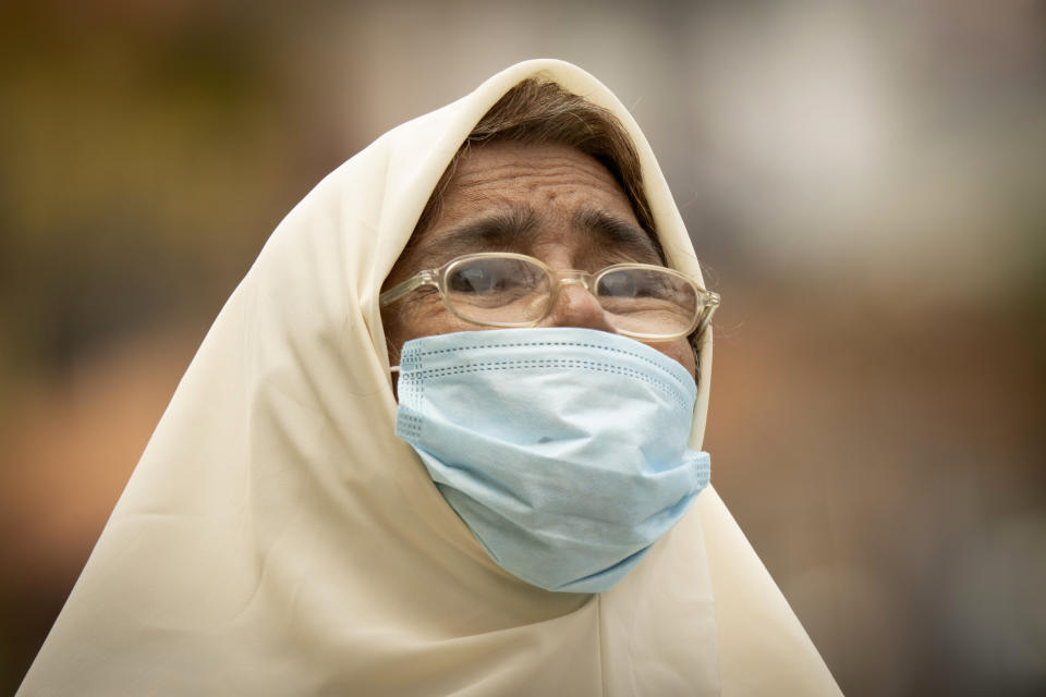 A Muslim woman wears a face mask to help curb the spread of the coronavirus near the locked down area of Selayang Baru, on the outskirt of Kuala Lumpur, Malaysia, on Sunday, April 26, 2020. The lockdown was implemented to allow authorities to carry out COVID-19 screenings to curb the spread of coronavirus. (AP Photo/Vincent Thian)