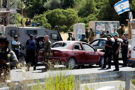 Israeli security forces gather at the scene where a female Palestinian was shot dead by Israeli troops at the entrance to Kiryat Arba near the West Bank city of Hebron June 24, 2016. REUTERS/Mussa Qawasma