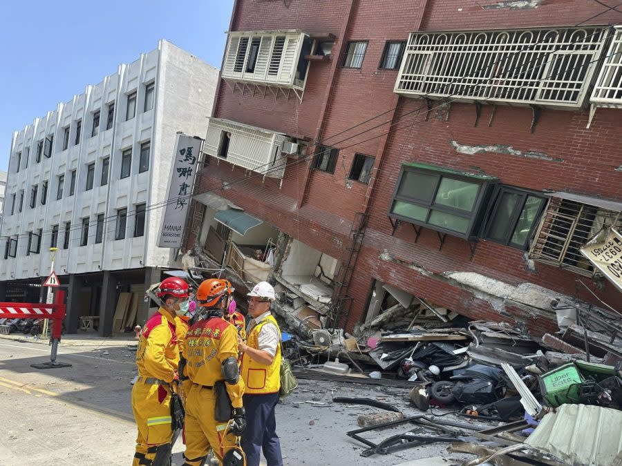 In this photo released by the National Fire Agency, members of a search and rescue team prepare outside a leaning building in the aftermath of an earthquake in Hualien, eastern Taiwan on Wednesday, April 3, 2024. Taiwan's strongest earthquake in a quarter century rocked the island during the morning rush Wednesday, damaging buildings and creating a tsunami that washed ashore on southern Japanese islands. (National Fire Agency via AP)