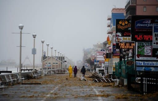 People walk on the boardwalk in Ocean City, Maryland, as Hurricane Sandy nears landfall in the area. Hurricane Sandy drove a deadly tidal surge into coastal cities along the eastern US coast Monday and pushed storm-force winds, torrential rain and heavy snow deep inland